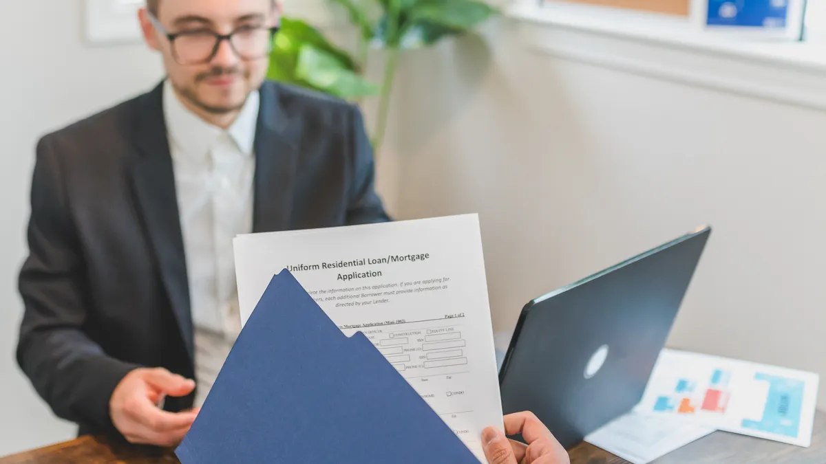 How to compare loan disclosures before you sign Man reviewing a loan document with a blue folder at a desk