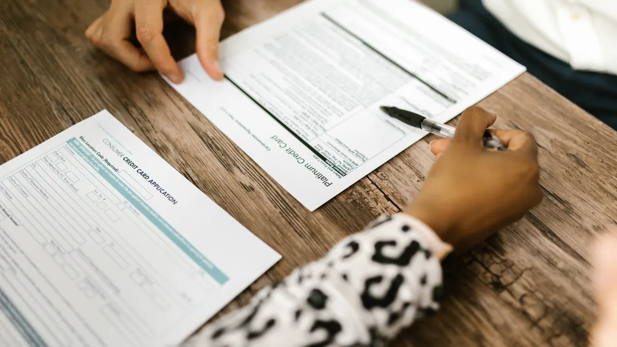 How to compare loan disclosures before you sign Close-up of hands comparing two paperwork forms on a table
