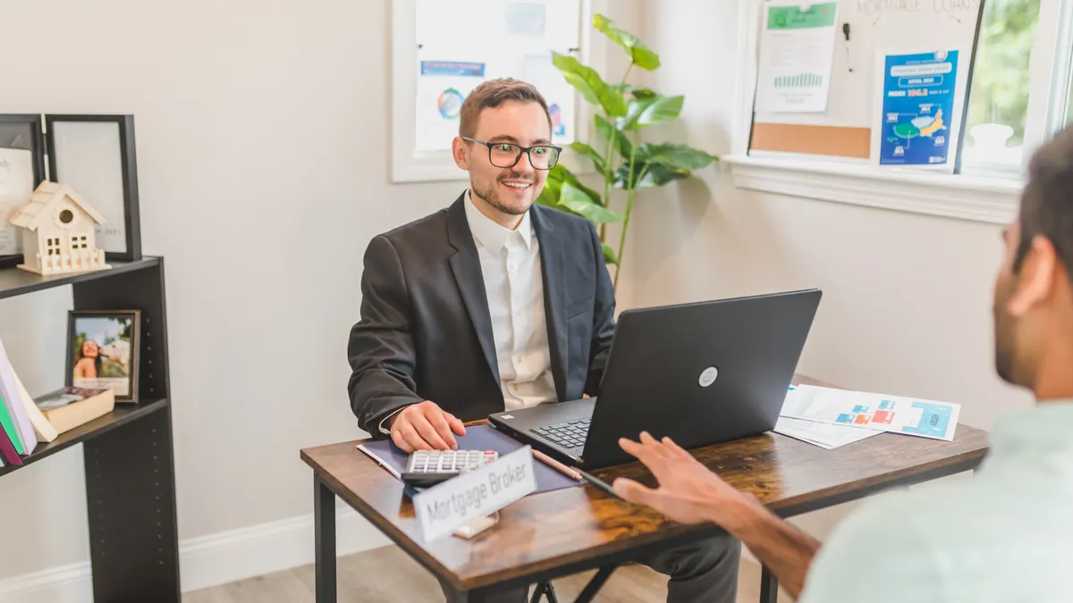 How to compare online lenders vs banks vs credit unions Loan advisor meeting with a client at a laptop